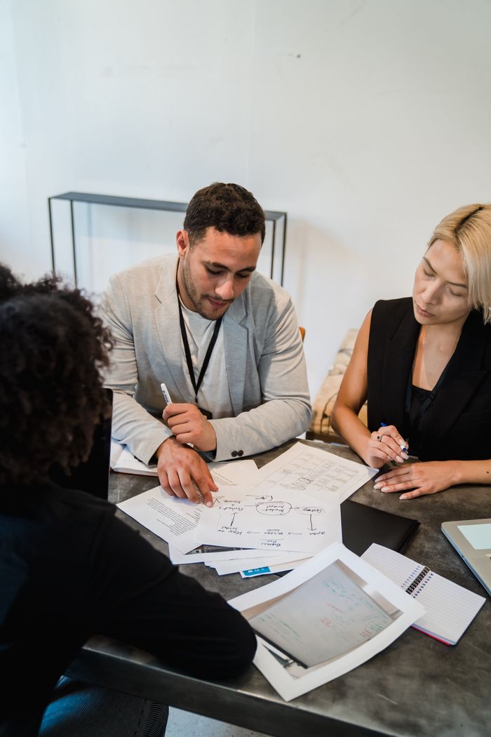 Crafting Captivating Headlines: Your awesome post title goes here Diverse team engaged in collaboration, reviewing documents at an office desk.