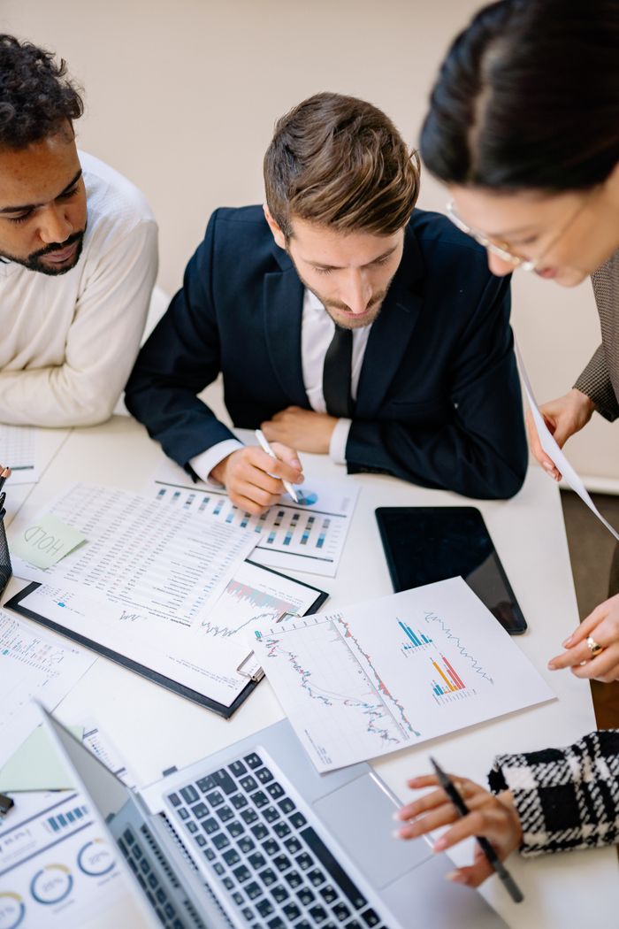 The Art of Drawing Readers In: Your attractive post title goes here Business professionals collaborating over charts and laptops in an office.